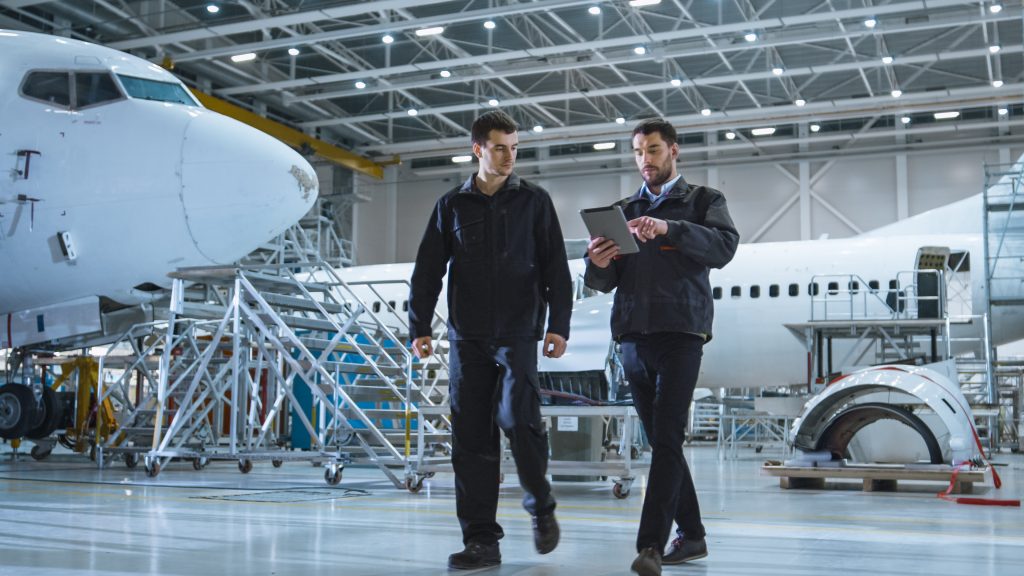 Two aerospace manufacturing managers walking with a tablet.