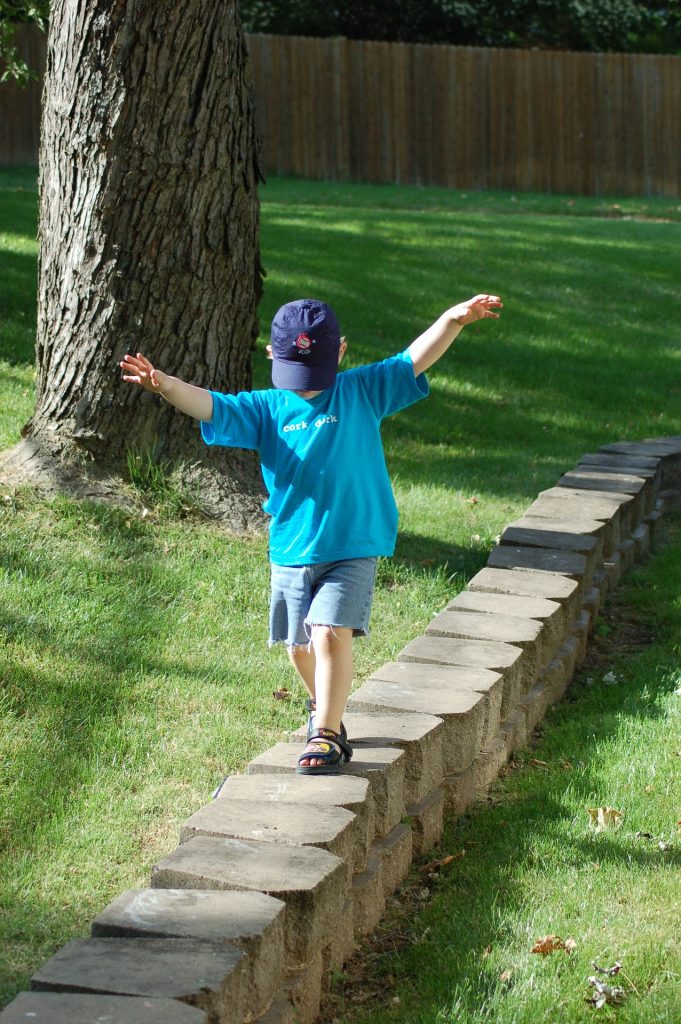 A child walking on bricks alone.