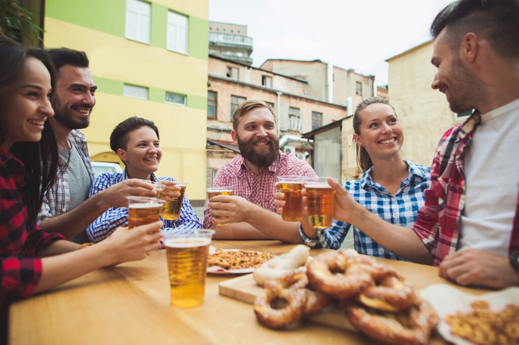 A group of friends drinking beer and enjoying pretzels.