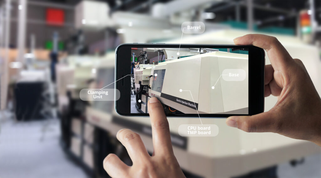 Augmented reality concept. AR. Industrial 4.0 , Hand of engineer holding mobile smart phone using virtual AR to check the work of electric machine on smart factory background.