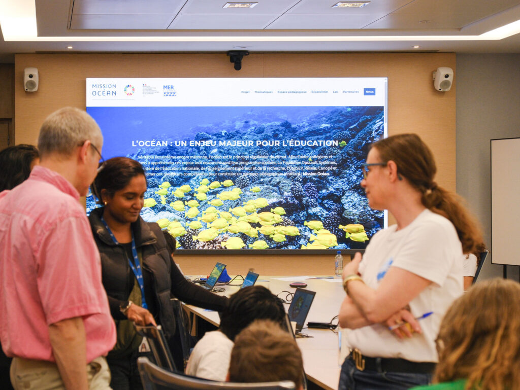 A group of children and adults participate in Mission Ocean, a climate-focused activity during Dassault Systèmes' KIDS' DAY at the Paris Campus.