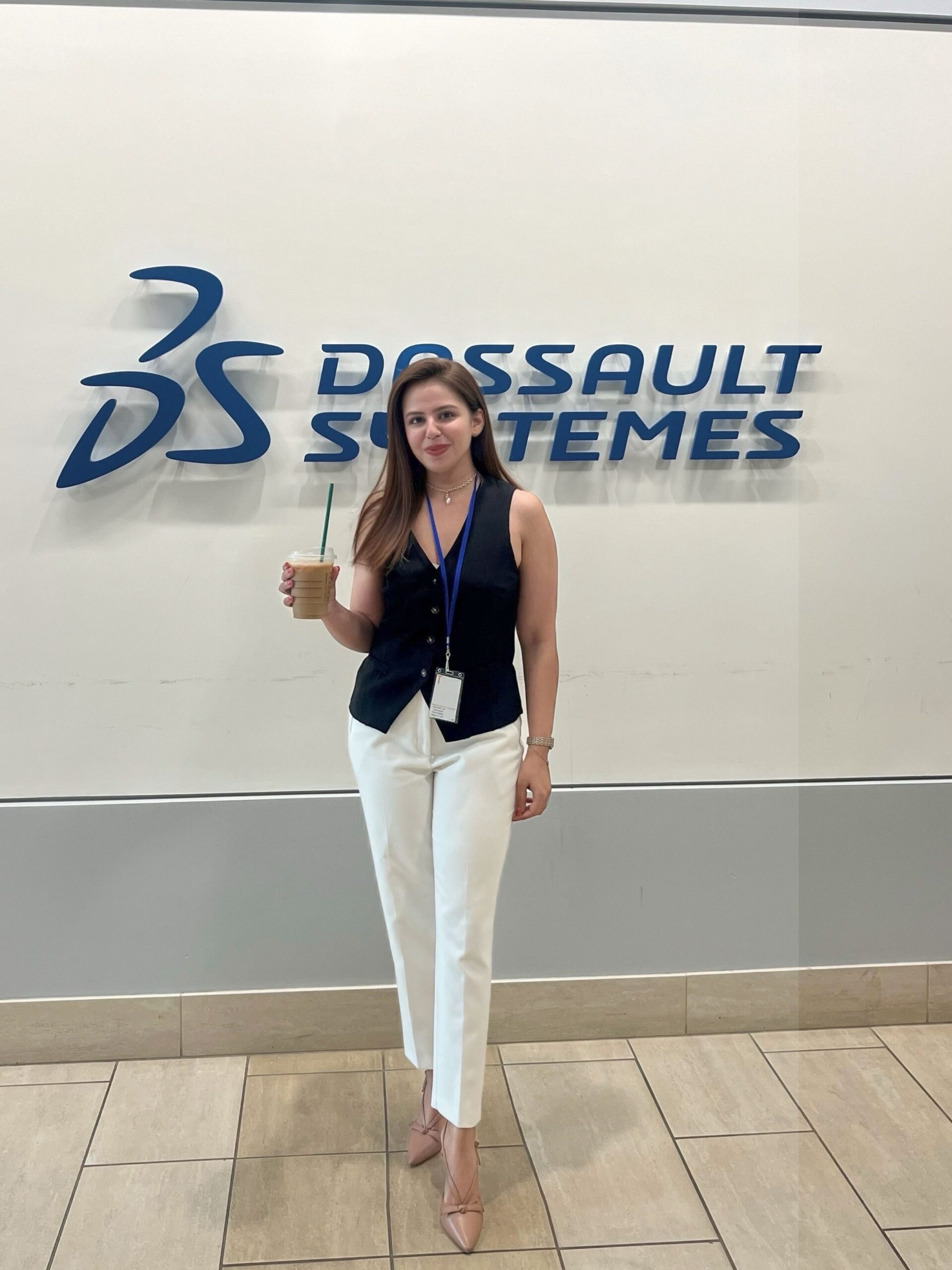 Vanessa Verma, Digital Marketing Strategies and Campaigns Intern, poses in front of the Dassault Systèmes logo.