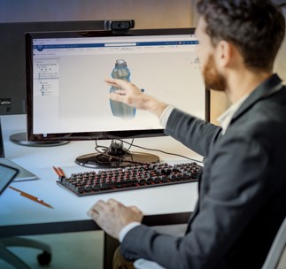 engineering working with a virtual twin of a bottle on the computer monitor