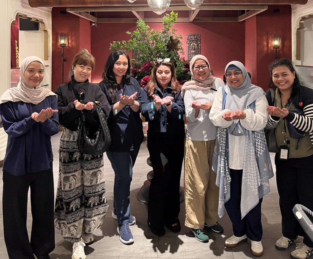 A group of Dassault Systemes employees holding out their hands in the "Give to Gain" pose for International Women's Day.
