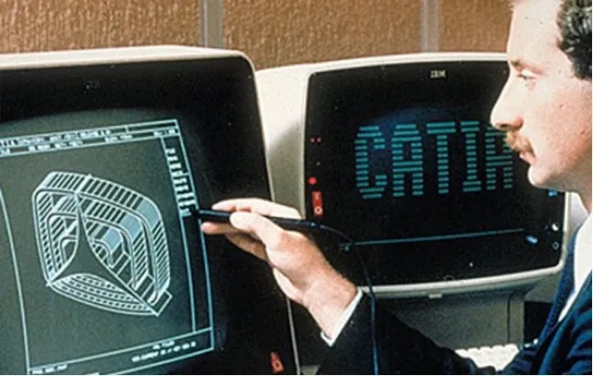 A man sits in front of a 1980s desktop computer showing CATIA software - history of Dassault Systemes - Dassault Systemes blog 